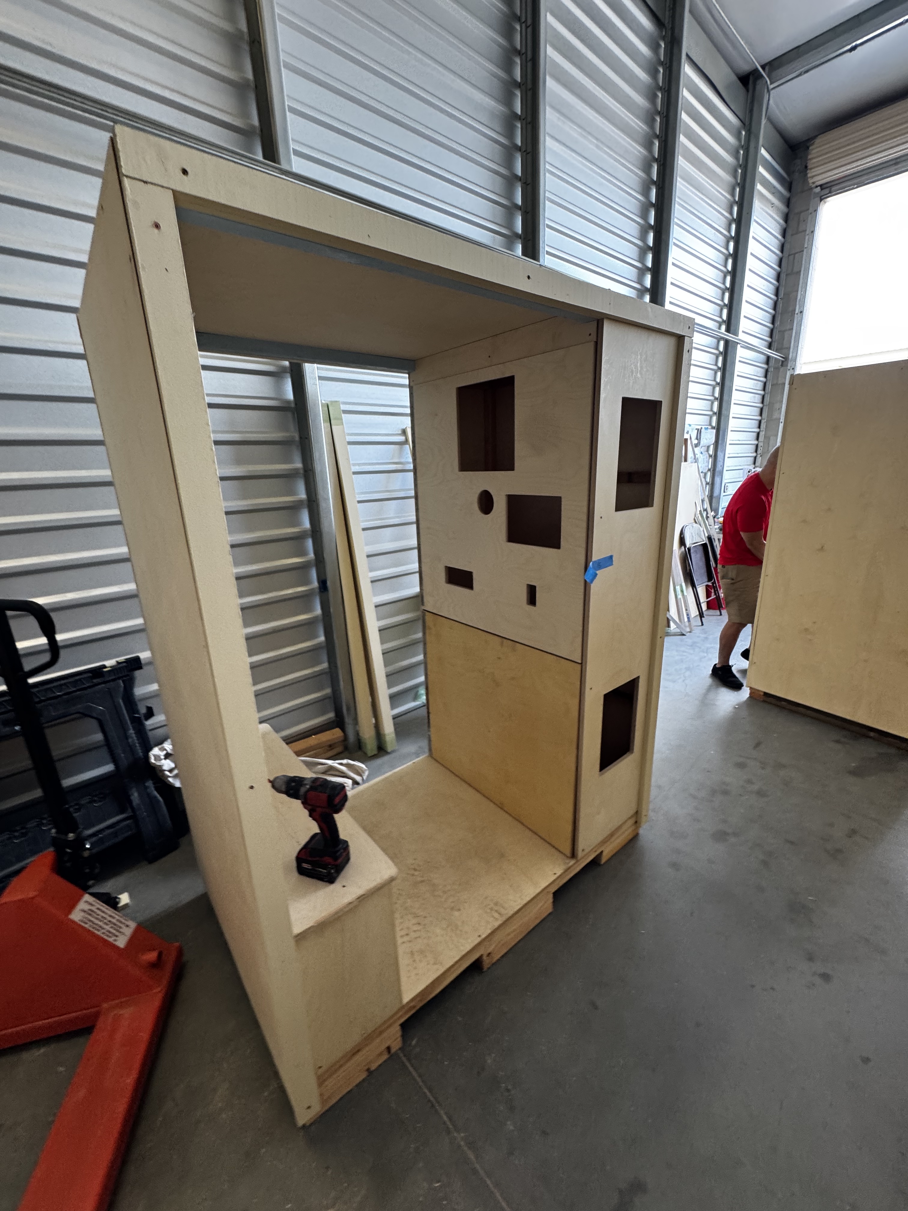 Unfinished wooden photo booth shell under construction in a workshop