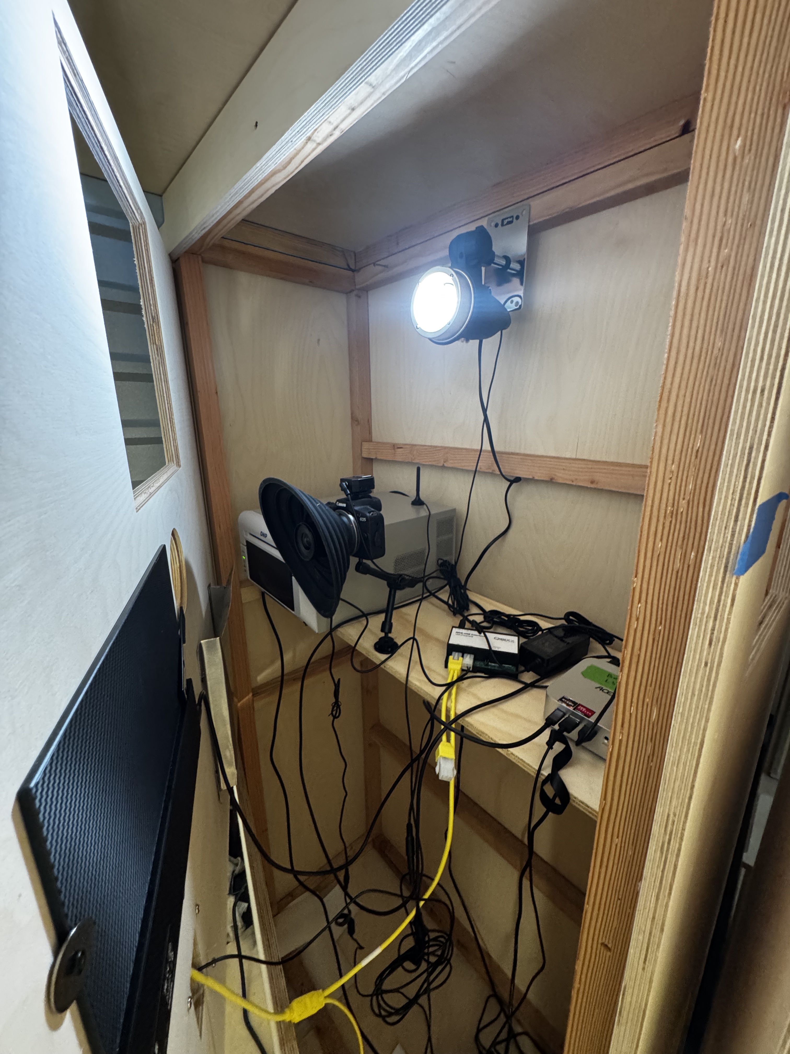 Camera, flash, printer, and cables installed inside a wooden festival photo booth