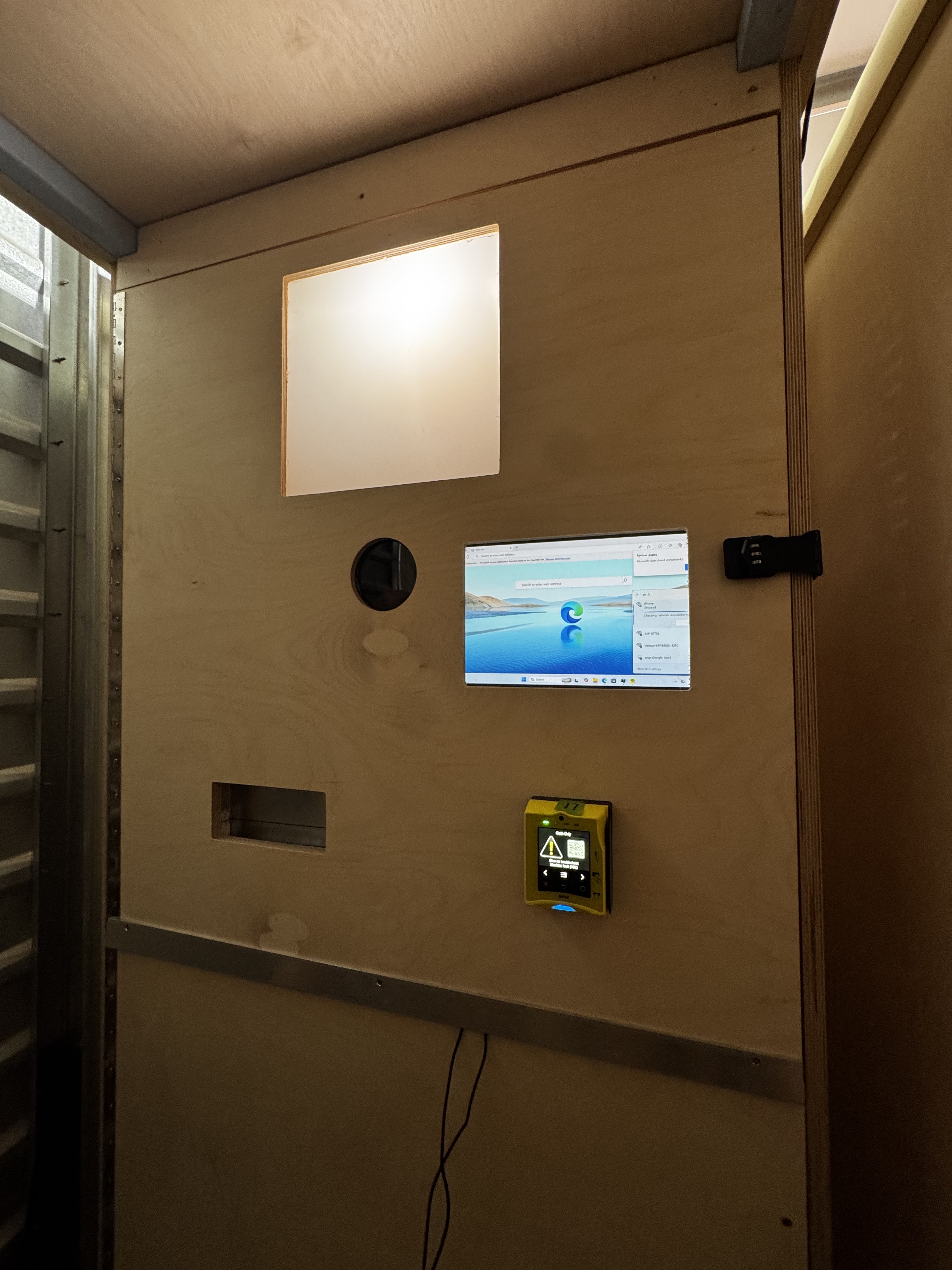 Photo booth interior panel with light, display, camera opening, and payment terminal
